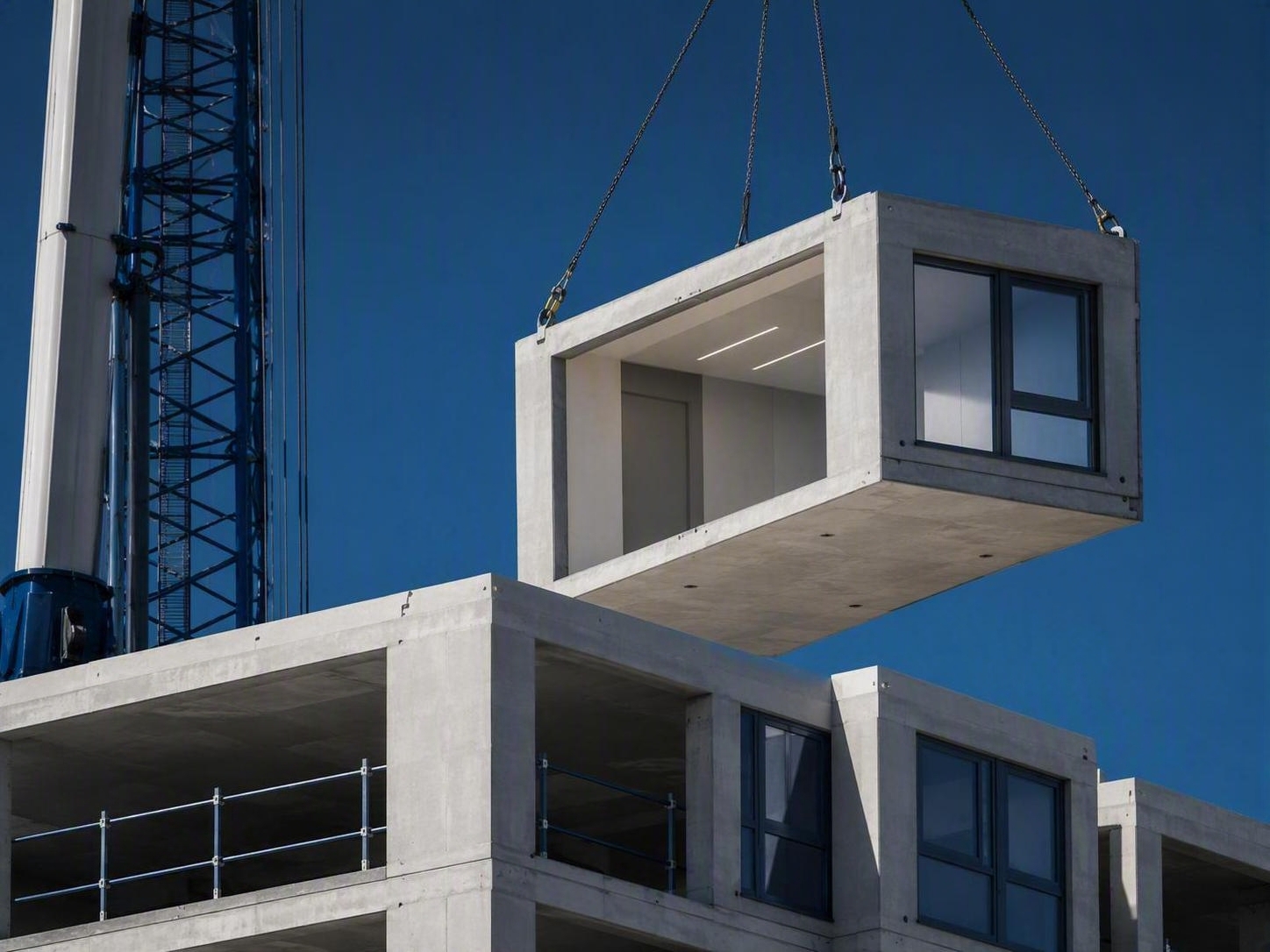 Concrete C-Module being lifted into position by crane