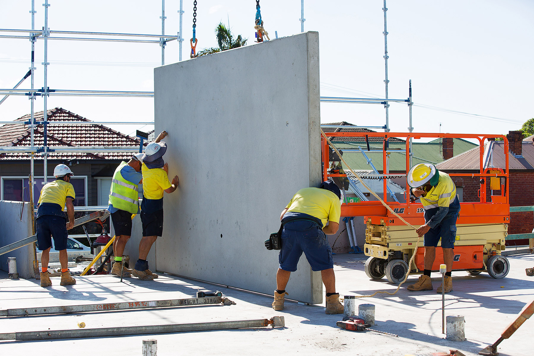 Site team guiding a precast concrete wall panel into position